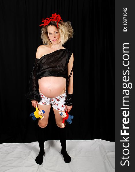 Extravagantly dressed pregnant woman on a black background