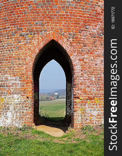 Looking through a Norman shaped arch of a Folly to an English Rural Landscape. Looking through a Norman shaped arch of a Folly to an English Rural Landscape