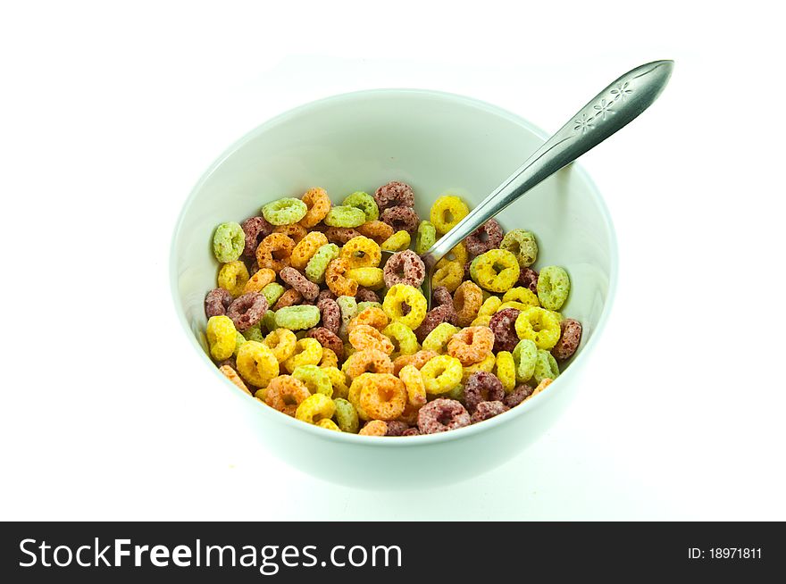 Bowl and spoon with corn flakes on the white background