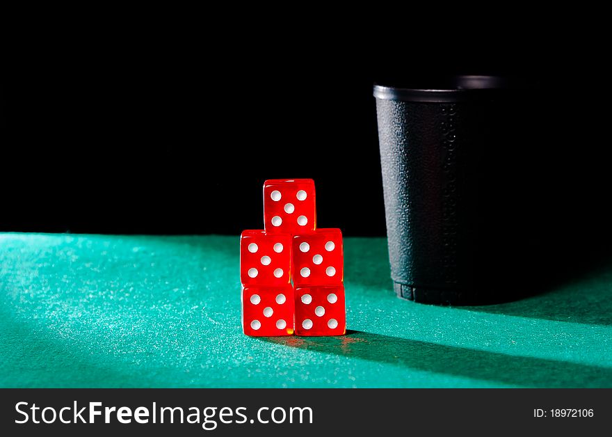 Poker with dice cube on playmat on black background