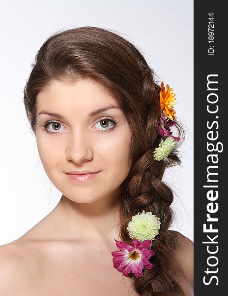Portrait of the beauty young brunette girl with flowers in her hair