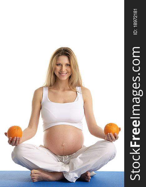 Pregnant woman practicing yoga with oranges isolated on white