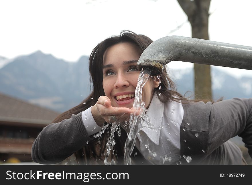 Smiling woman drinking water from a fountain. Smiling woman drinking water from a fountain