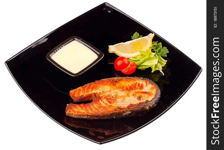 Grilled salmon steak with sauce and lemon isolated