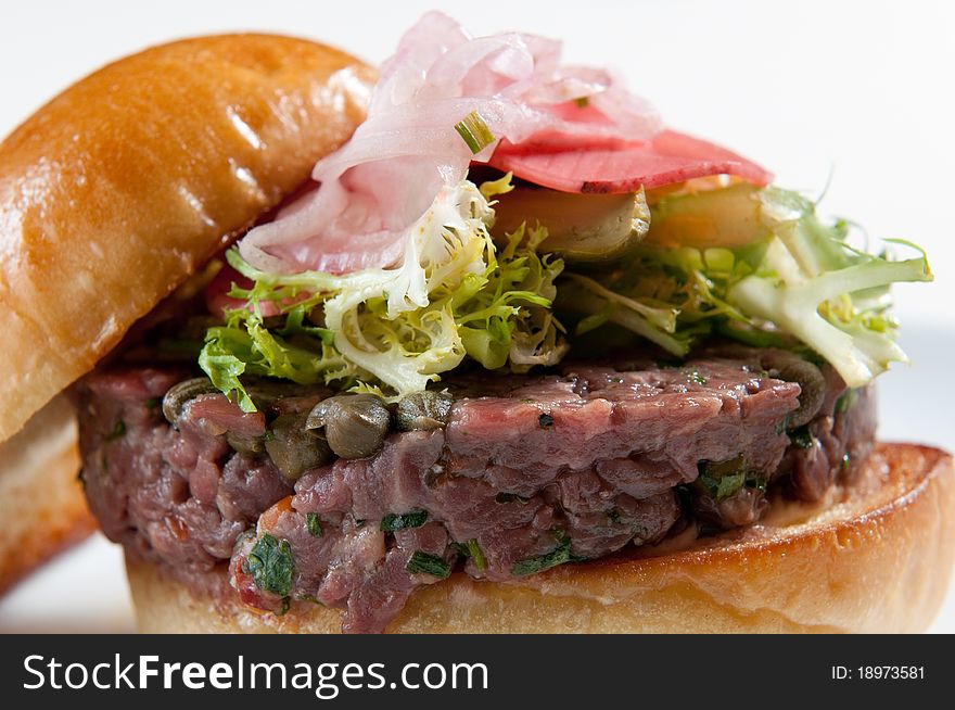 Fresh tar-tar burger with endive lettuce, onion, and radish