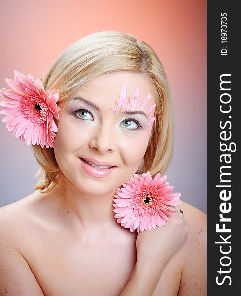 Close-up of woman green eye. Pink flower on background. Close-up of woman green eye. Pink flower on background.