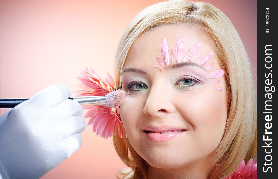 Close-up of woman green eye. Pink flower on background. Close-up of woman green eye. Pink flower on background.