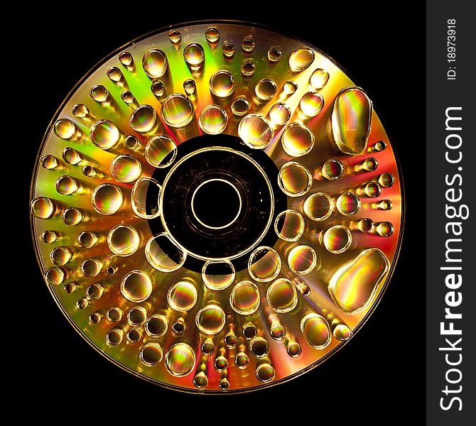 Compact Disc CD with water drops on the data surface with a shiny colorful reflection. Compact Disc CD with water drops on the data surface with a shiny colorful reflection