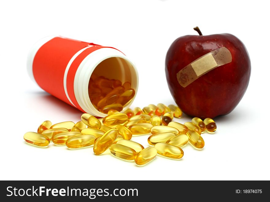 A plastered red apple and many capsules isolated on white background. A plastered red apple and many capsules isolated on white background.