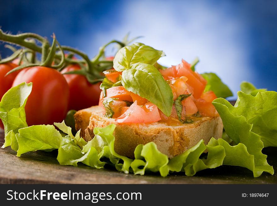 Photo of delicious bruschetta appetizer with tomatoes and basil. Photo of delicious bruschetta appetizer with tomatoes and basil