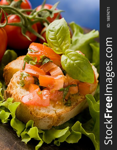 Photo of delicious bruschetta appetizer with tomatoes and basil. Photo of delicious bruschetta appetizer with tomatoes and basil