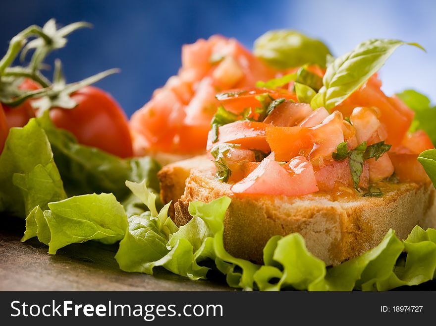 Photo of delicious bruschetta appetizer with tomatoes and basil. Photo of delicious bruschetta appetizer with tomatoes and basil