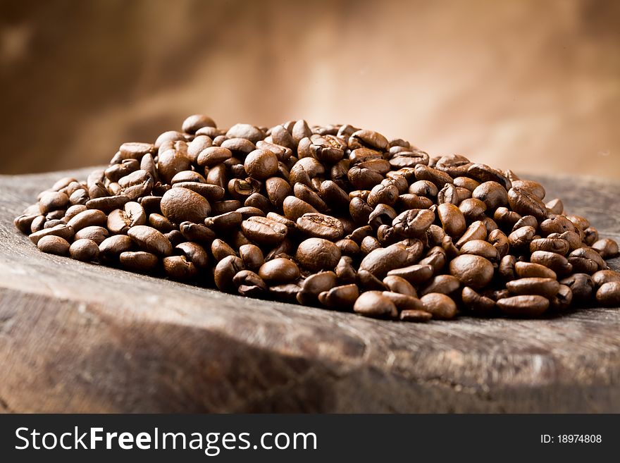 Photo of brown delicious roasted coffee beans on wooden table