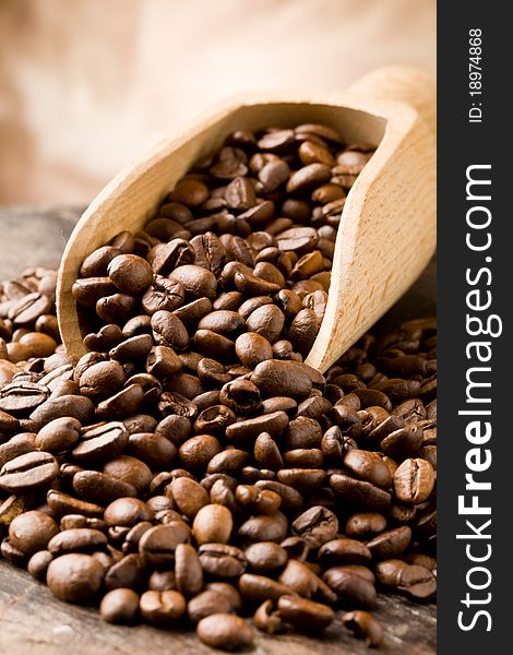 Photo of brown delicious roasted coffee beans on wooden table