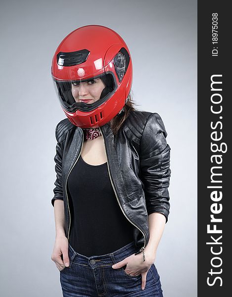 Caucasian motorcyclist posing with black jacket and red helmet. Caucasian motorcyclist posing with black jacket and red helmet