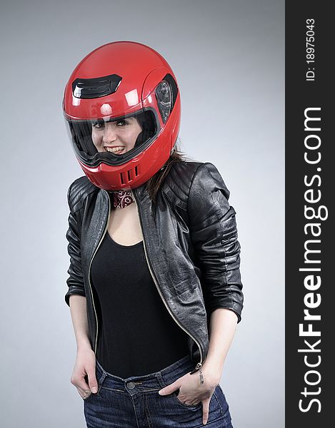 Caucasian motorcyclist posing with black jacket and red helmet. Caucasian motorcyclist posing with black jacket and red helmet