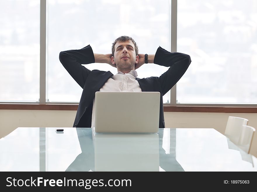 Young business man lawyer with laptop alone in big bright conference room. Young business man lawyer with laptop alone in big bright conference room