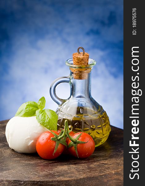 Photo of tomato mozzarella on wooden table in front of blue background