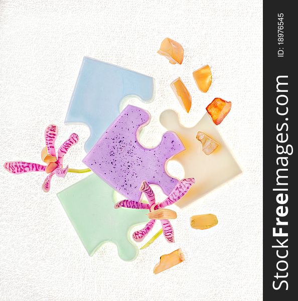 Soap, flowers and amber on a white towel