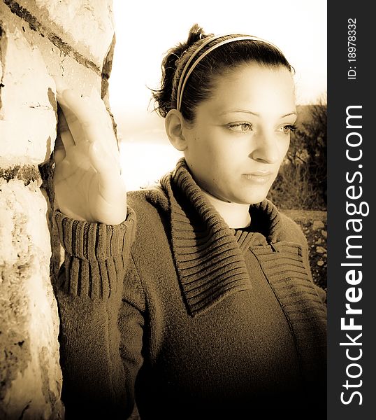 Portrait of beautiful young woman, pretty eyes and thoughtful look, holding by the wall