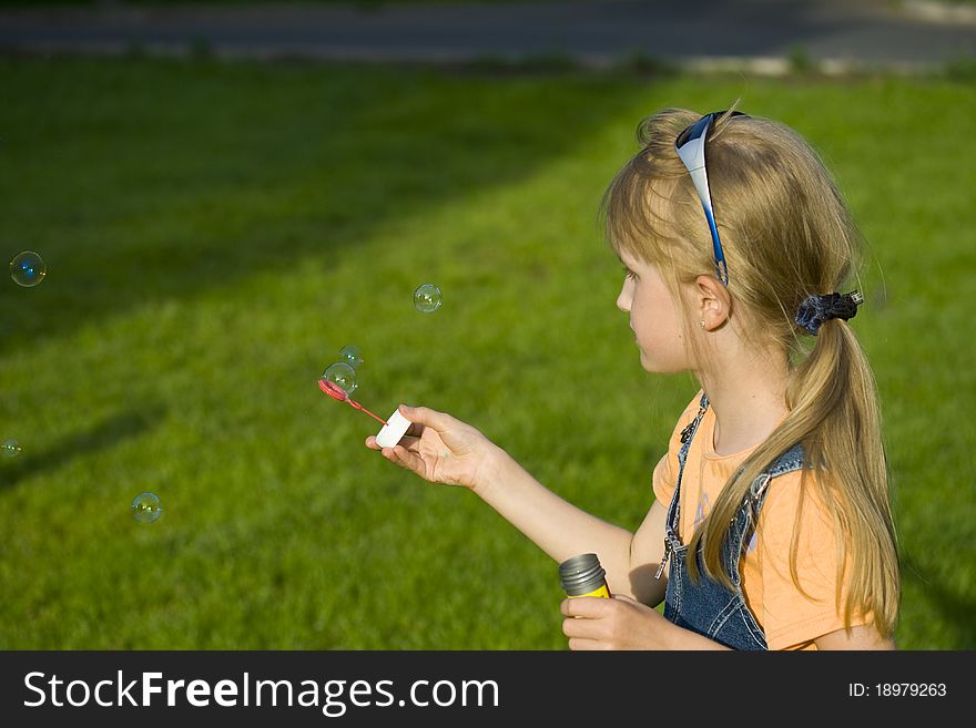 The girl plays with soap bubbles