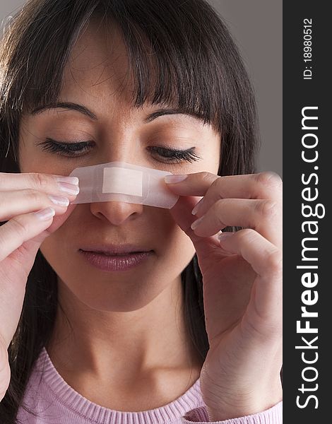 Woman applying bandage on nose