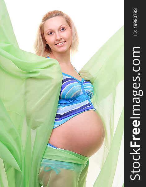 Beautiful young pregnant blonde woman with green transparent cloth in studio. Beautiful young pregnant blonde woman with green transparent cloth in studio