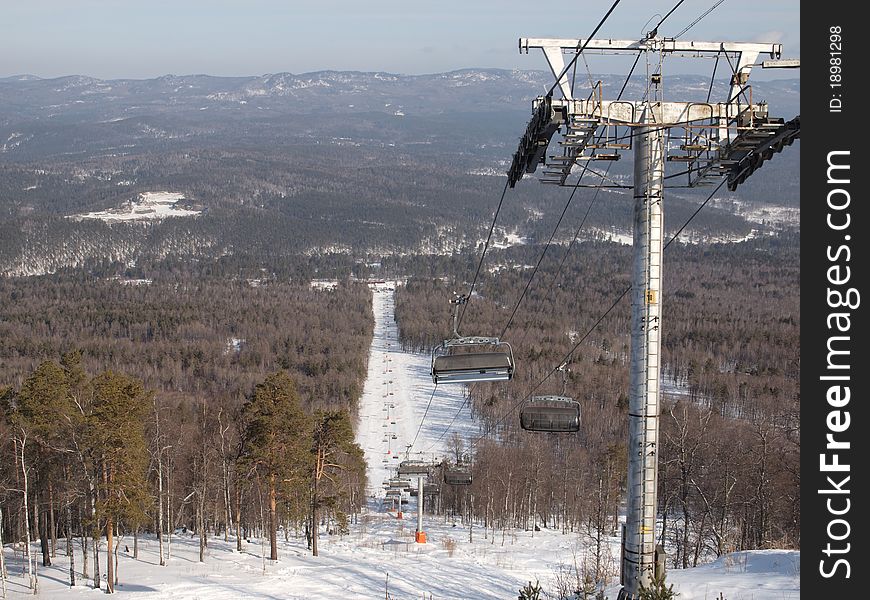 Ski lift on the slope of a forested. Ski lift on the slope of a forested