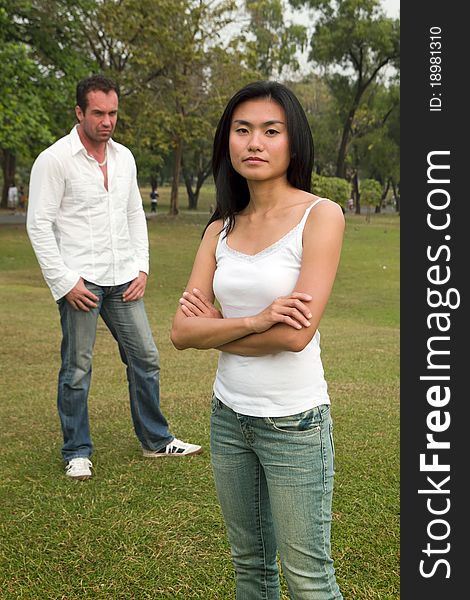 Woman do not look happy standing in front of man standing