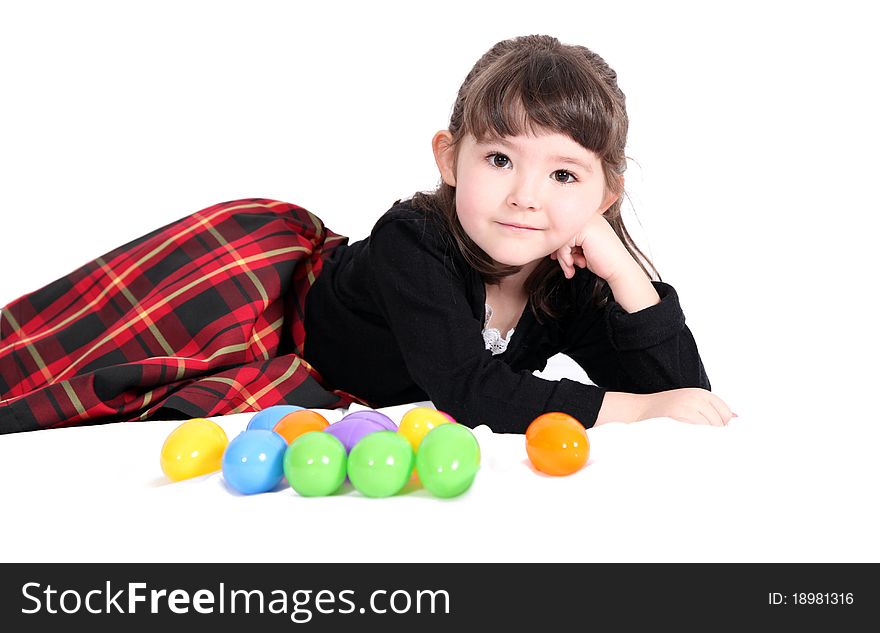 Adorable little girl lying down with easter eggs isolated on white