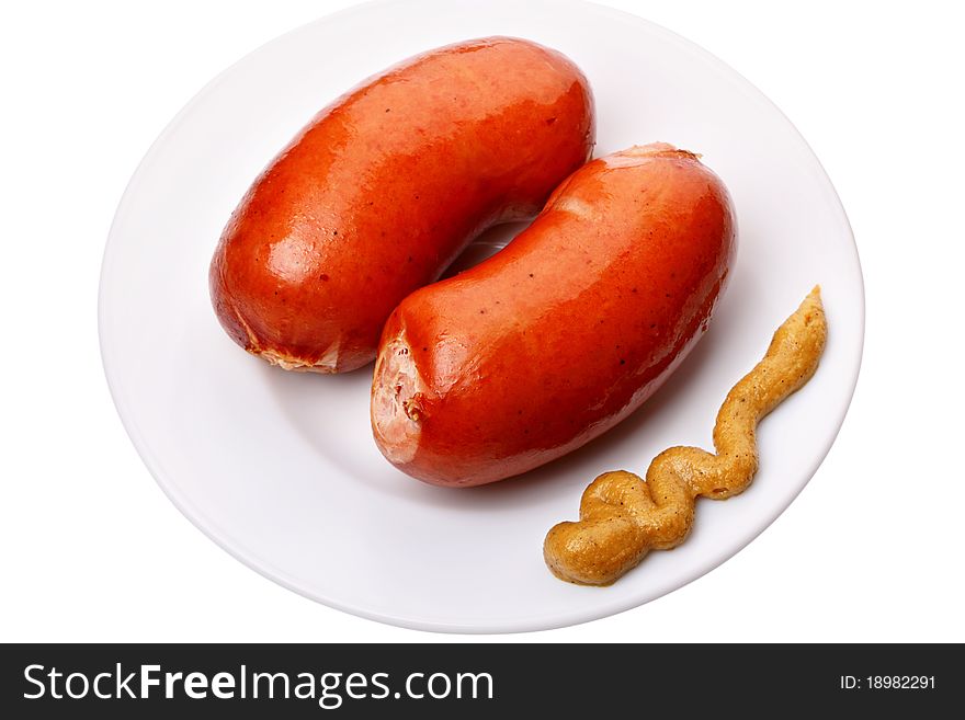 Boiled sausages with mustard on a white plate