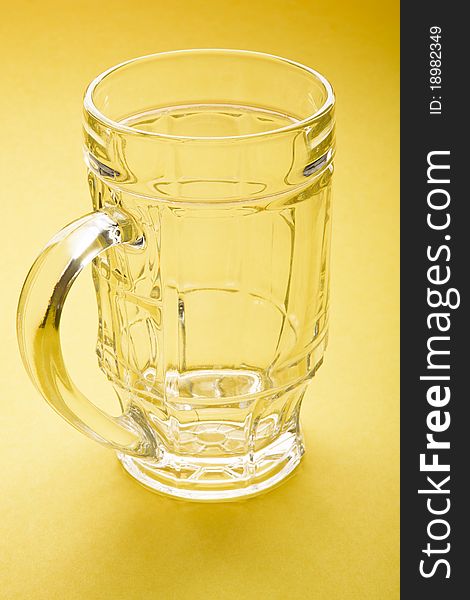 Empty beer mug on a yellow background