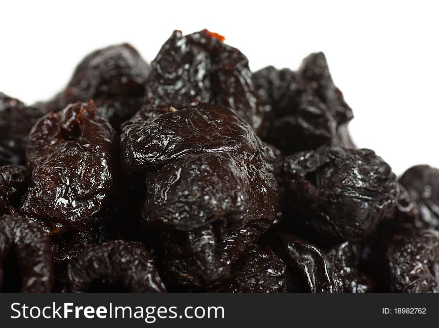 A heap of dried fruits prunes over white background