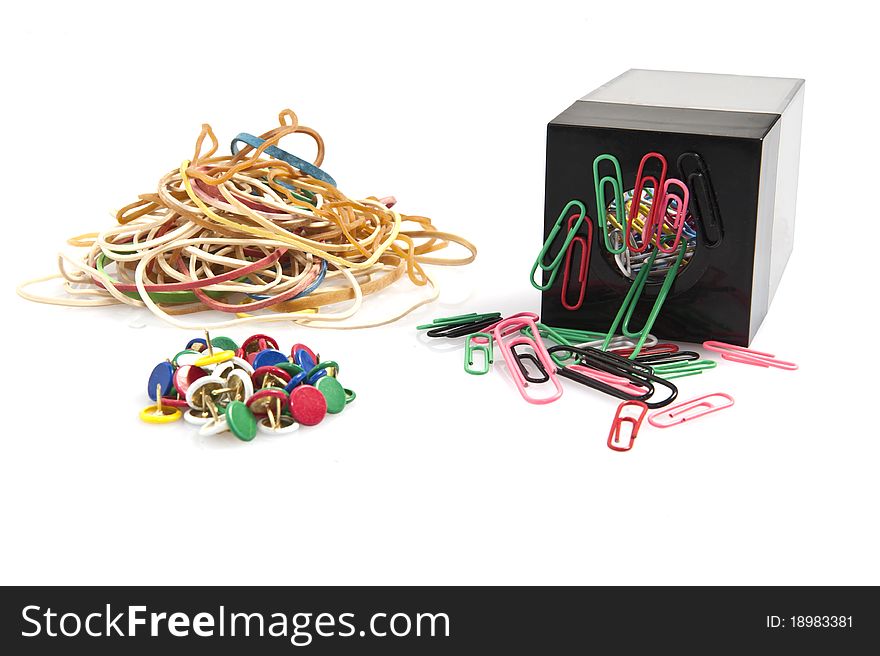 Rubber bands, paper clips and colored pins on white background. Rubber bands, paper clips and colored pins on white background