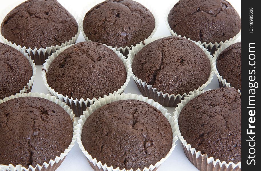 Chocolfte cake as background. Muffins