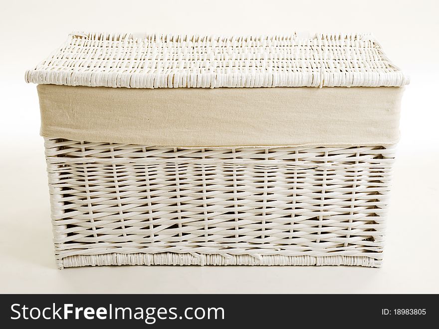 A closed white wicker toy basket isolated against a white background. A closed white wicker toy basket isolated against a white background