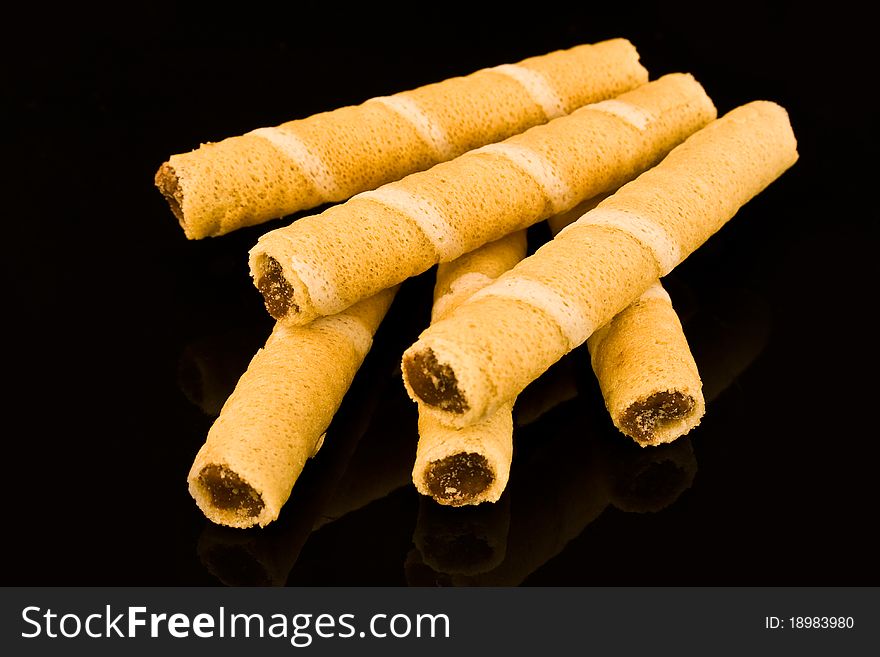 Wafer rolls with chocolate filling on black background