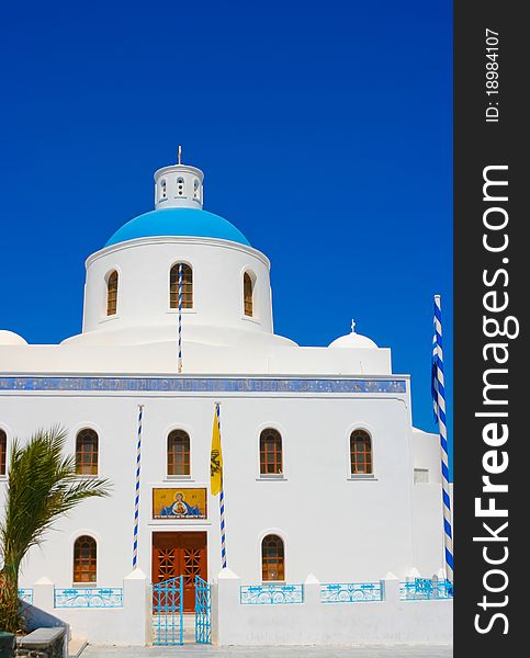 Beautiful white belfry of greek church on island of Santorini in Oia, Greece. And square with greece national flag. Beautiful white belfry of greek church on island of Santorini in Oia, Greece. And square with greece national flag.
