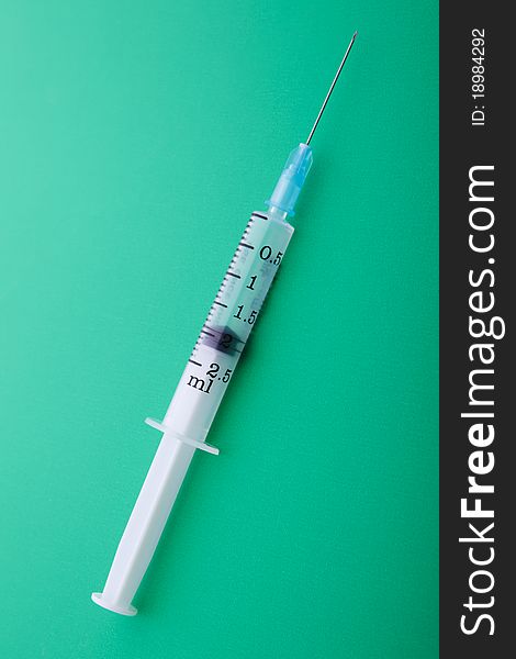 Medical syringe. First aid. On a green background.