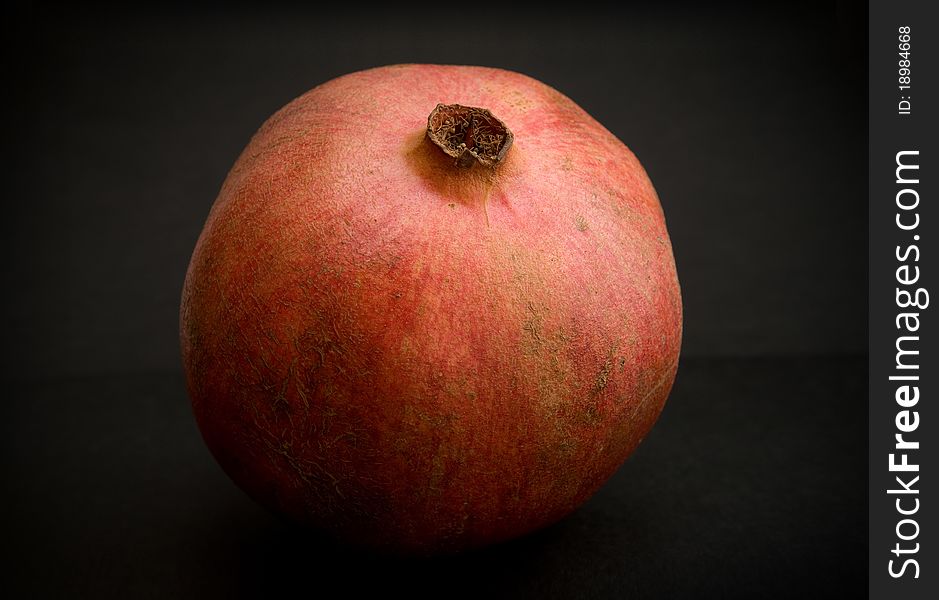 Perfect fresh pomegranate at dark background