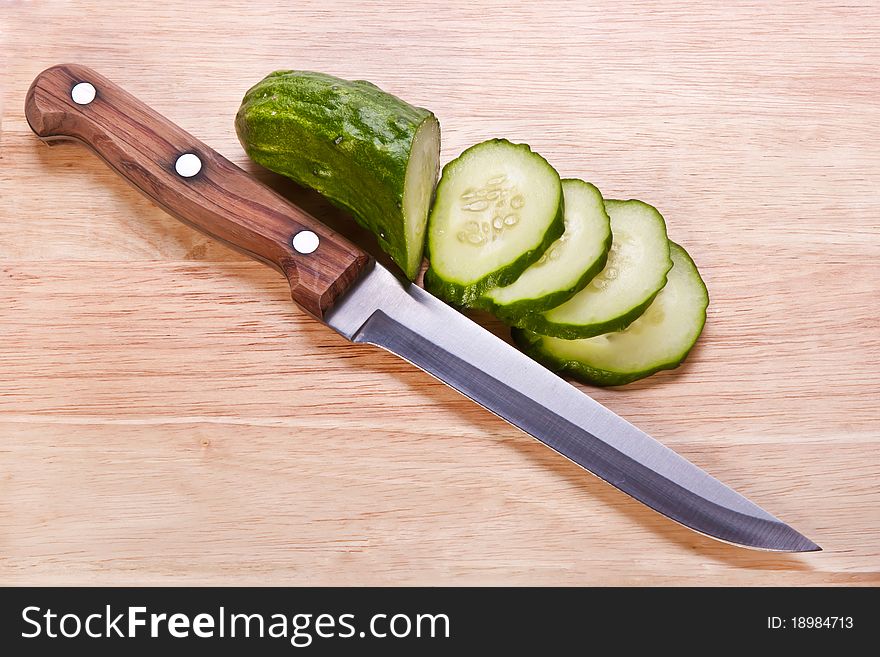 Cut cucumber with a knife on the cutting board