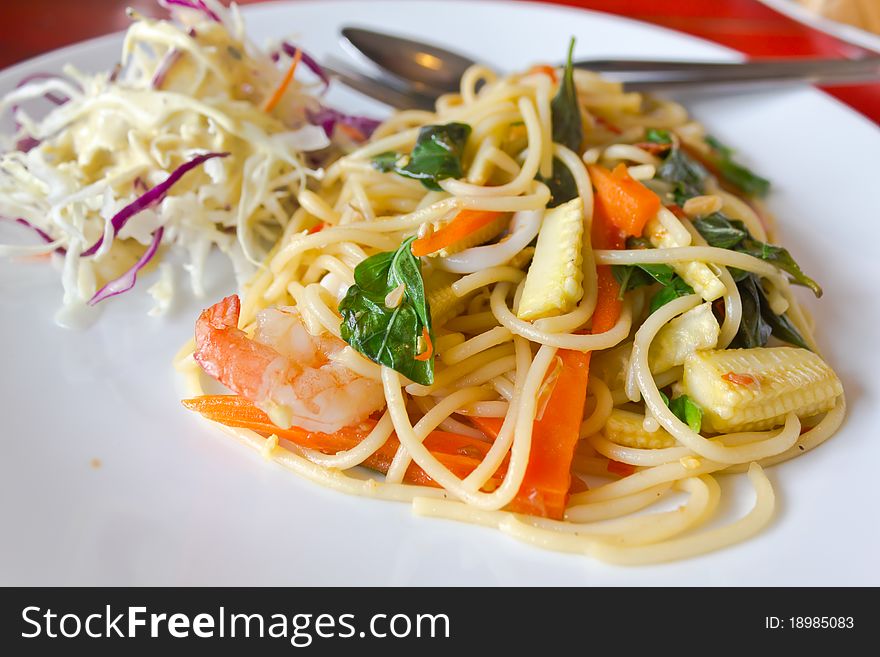 Spaghetti whit shrimp and basil fried on a white dish