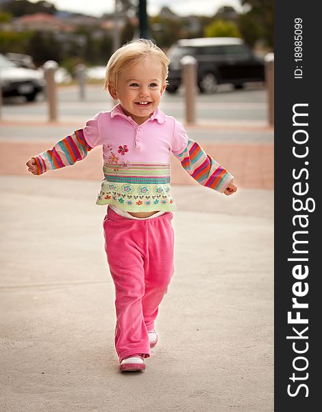 Little girl running towards camera with open arms. Little girl running towards camera with open arms