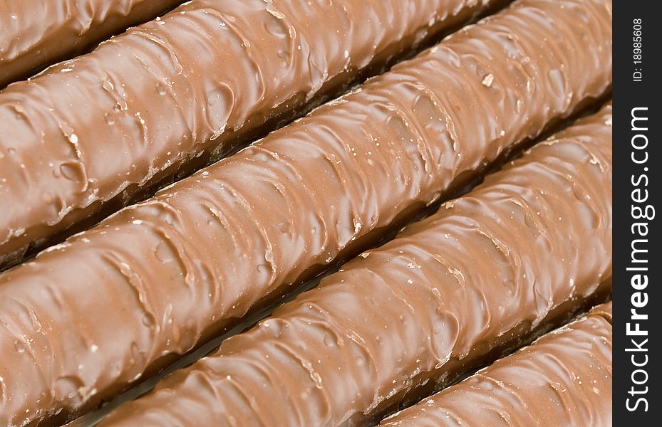Chocolate bars are stacked in the form of background. Chocolate bars are stacked in the form of background