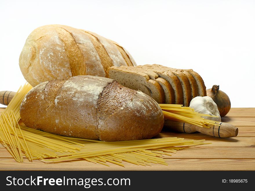 Assortment of baked bread on a wooden table on a white background