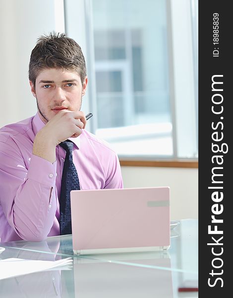 Young business man lawyer with laptop alone in big bright conference room. Young business man lawyer with laptop alone in big bright conference room