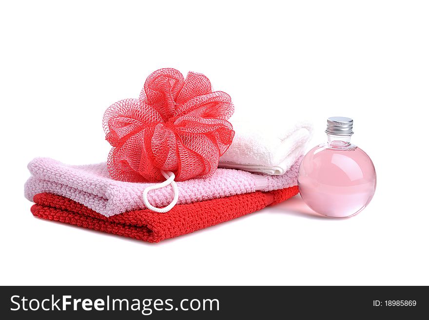 Stacked towels with red soap roses and bottle with soap gel on white background. Stacked towels with red soap roses and bottle with soap gel on white background