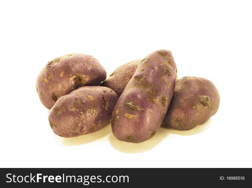 Bunch of purple potatoes isolated on white.