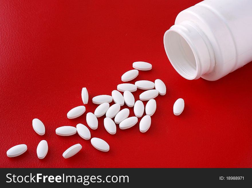Spread and a bottle of pills lying on a red background. Spread and a bottle of pills lying on a red background