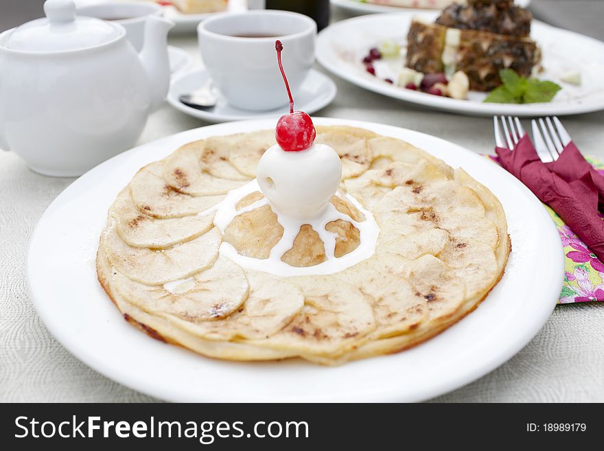 A table set with dessert, an apple pie with ice cream